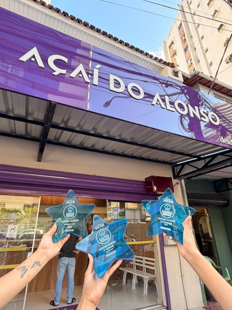 Os três troféus Estrela Azul erguidos na frente da loja